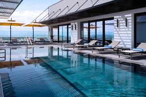 A modern indoor swimming pool with clear water, sun loungers, and umbrellas. - Tunis Marriott Hotel (Tunis)