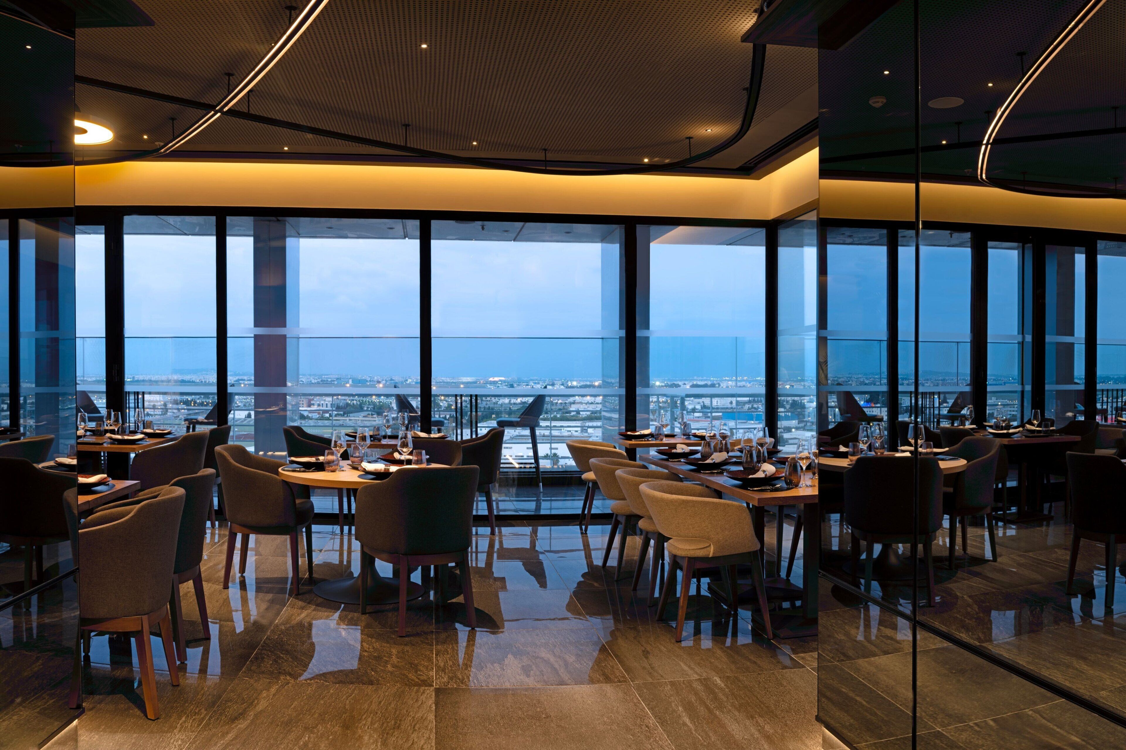 A modern dining area with large windows offering a city view.