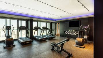 A modern gym with treadmills, stationary bikes, and weight machines.