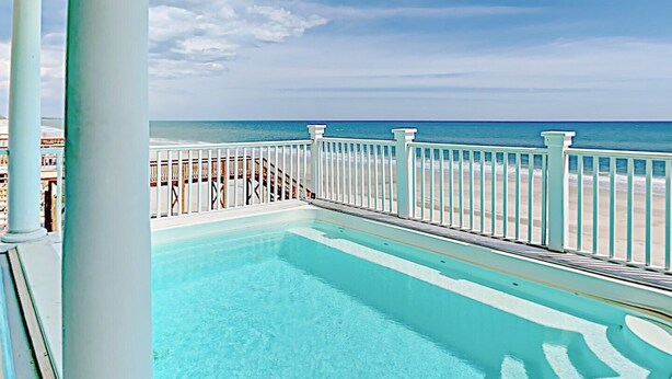 Une piscine avec vue sur la plage et l’océan.