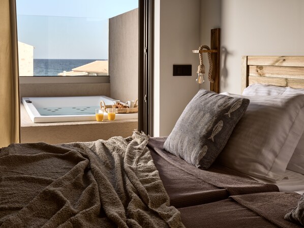 Ein Schlafzimmer mit einem großen Fenster mit Blick auf einen Pool und das Meer.