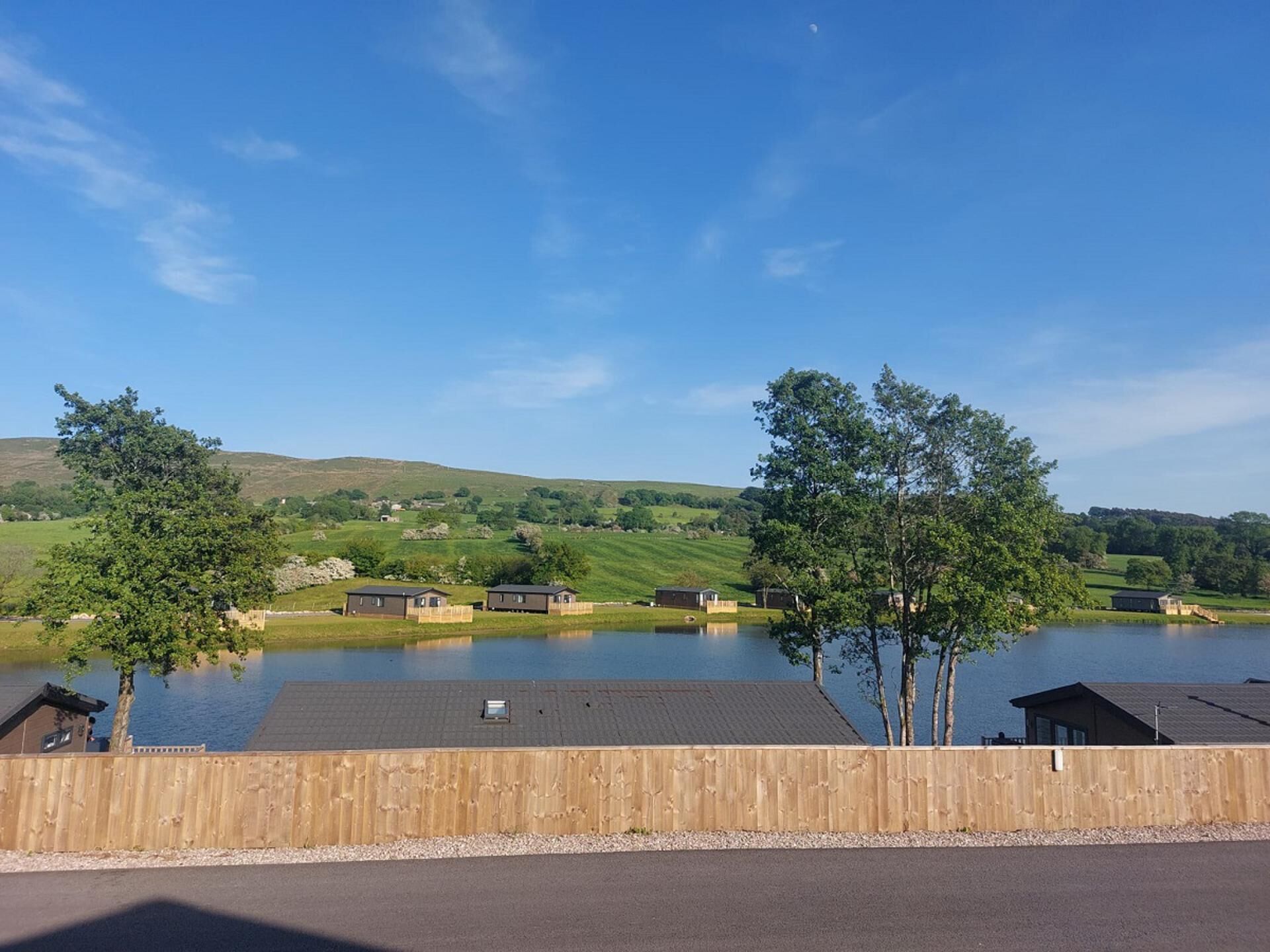 A lakeside view with wooden cabins and a clear sky.