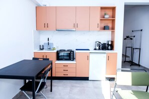 A compact kitchen with peach cabinets, a black microwave, and a coffee maker. - Veranda Apt close to Monastiraki - 1 (Athens)