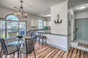 Enjoy meals in this dining area with a glass-top table and six chairs, surrounded by a large window offering a view of the outdoors.
