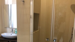 A modern bathroom with a glass-enclosed shower, a sink, and a mirror. - Dante 3 Guesthouse (Bari)