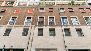 Ein mehrstöckiges Gebäude mit einer beigen Fassade, zahlreichen Fenstern und Balkonen.
