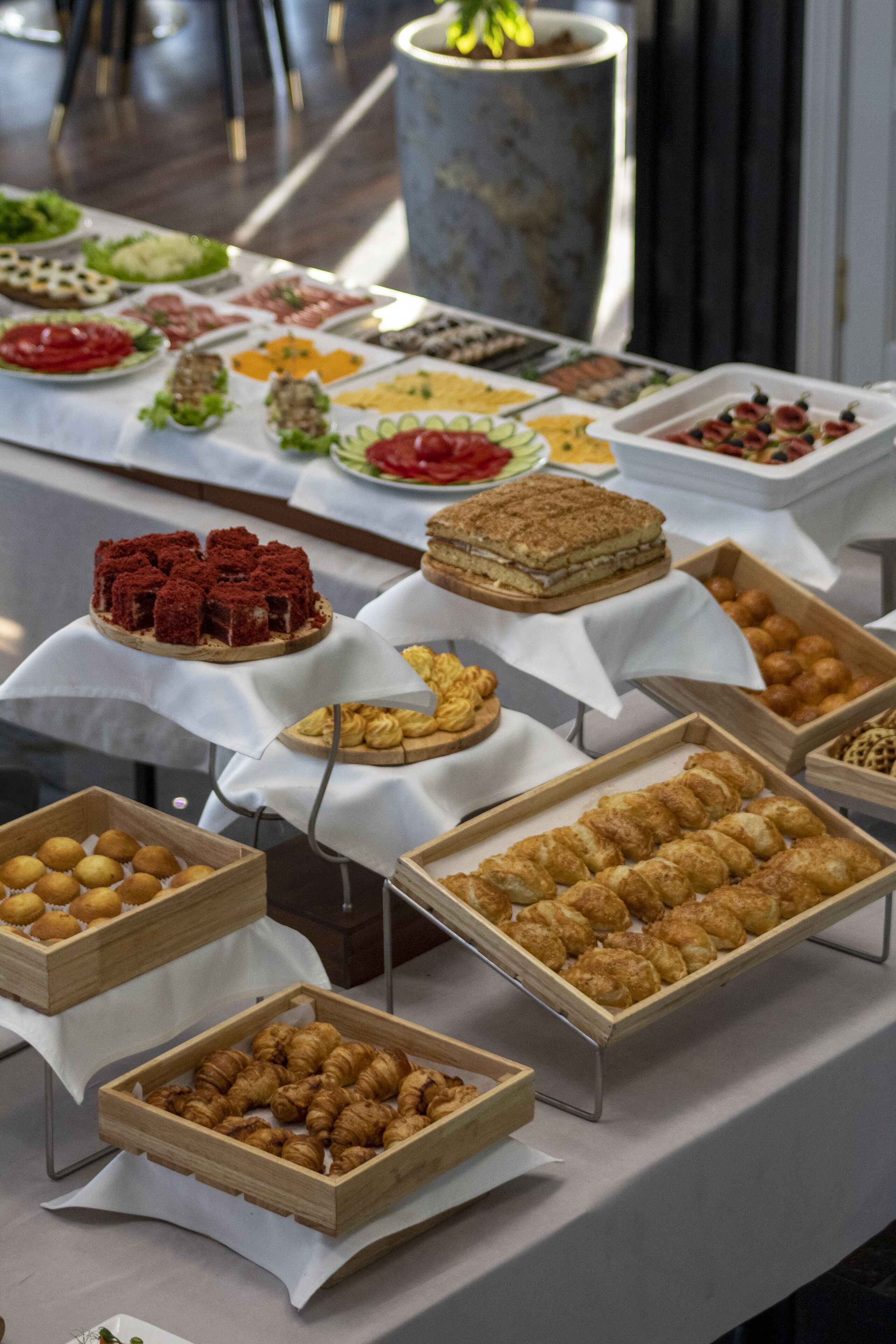 A buffet with various food items including pastries, fruits, and desserts.