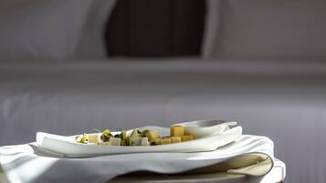A neatly arranged breakfast buffet with various cheeses and garnishes on a white plate, set on a table with a white tablecloth.