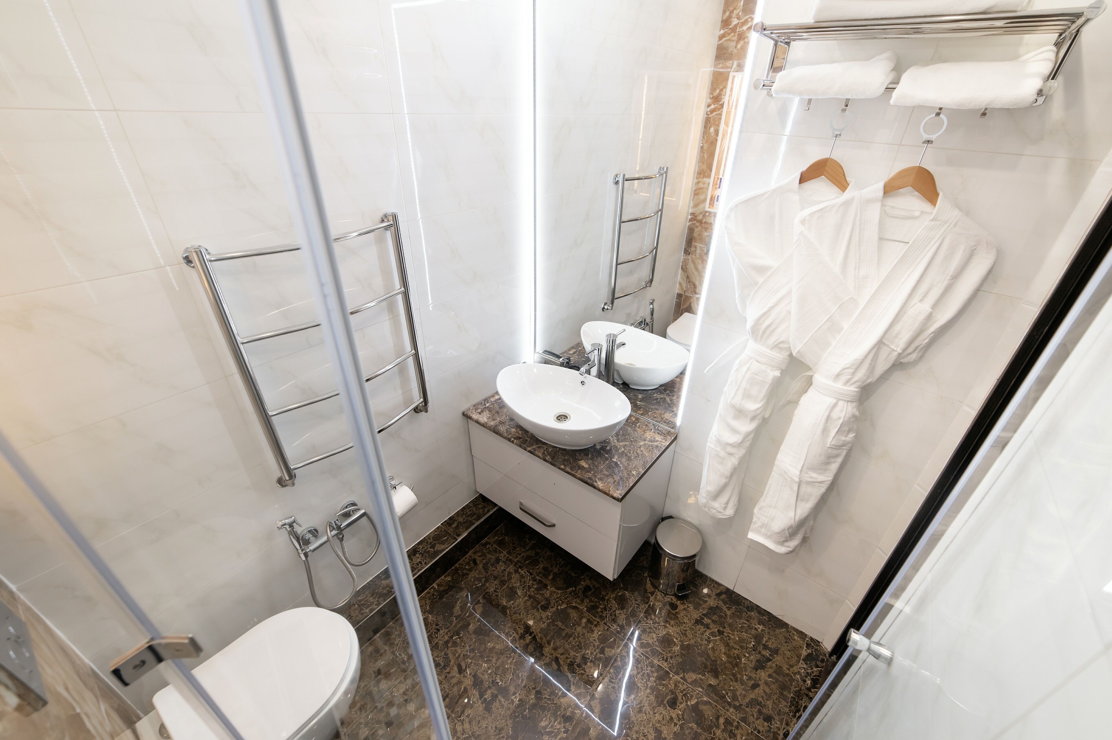 Un bagno piccolo e funzionale con box doccia in vetro, lavabo bianco e servizi igienici.