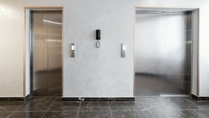 A modern elevator with a marble wall and a security intercom. - Orient Hotel Bishkek (Bishkek)