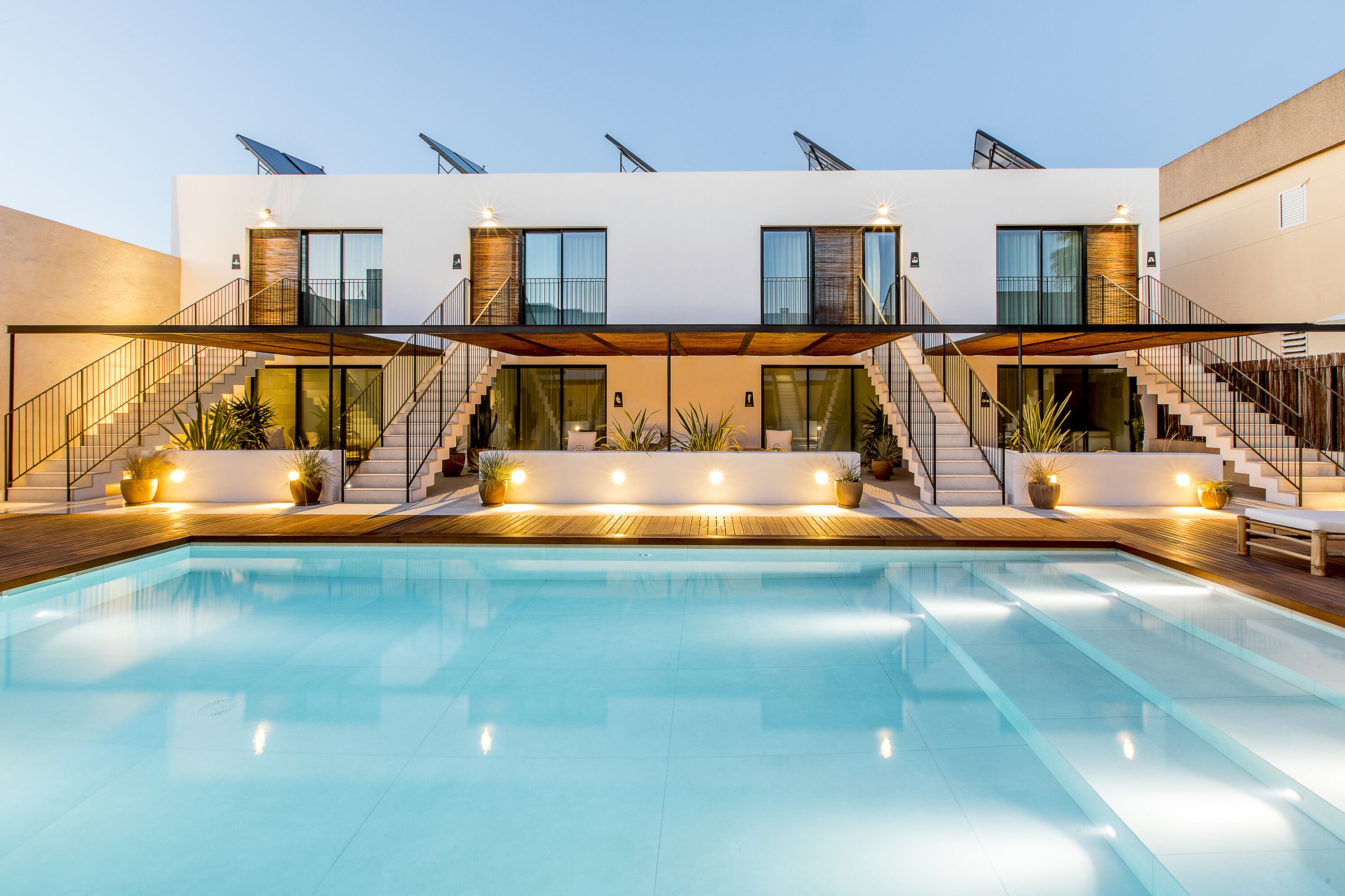 A modern building with a swimming pool, multiple staircases, and large windows.