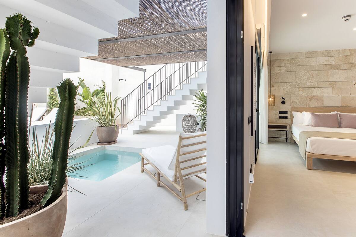A modern interior with a pool, a staircase, and a bed.