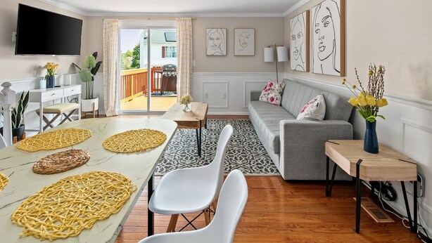 A modern living room with a dining area, grey sofa, and artwork on the walls. - Asbury: Work Friendly & 40 Mins to DC (Sterling)