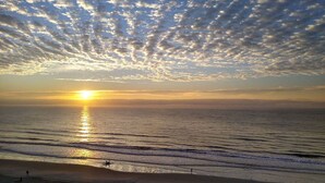 A beach with a sunset, waves, and a clear sky. - Coastal Condo w/ Balcony in North Myrtle Beach! (North Myrtle Beach)