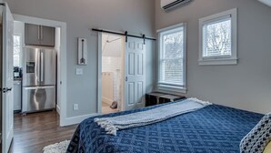 A bedroom with a bed, a window, an air conditioner, and a kitchenette. - King-bed Mural loft near 12 South with easy access to local attractions (Nashville)