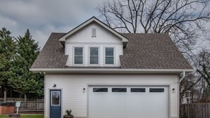 A two-story house with a garage, a front door, and a small porch area. - King-bed Mural loft near 12 South with easy access to local attractions (Nashville)
