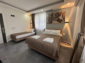 A hotel room with two beds, a large floral artwork on the wall, and a modern design. - Babil Hotel (Konyaalti)