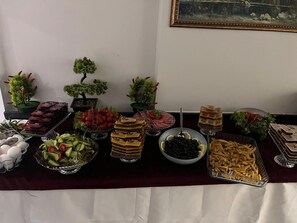 A buffet table with various food items, including fruits, vegetables, and sandwiches. - Babil Hotel (Konyaalti)