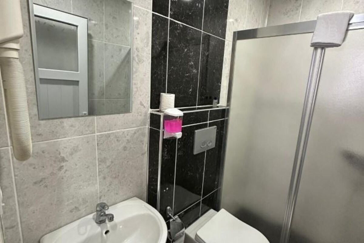 A bathroom with a sink, toilet, and shower.
