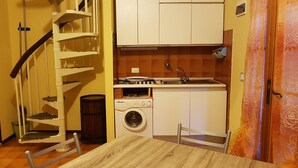A compact kitchen with a washing machine, a stove, and a sink. - Sea view apartment with 2 bedrooms and 2 bathrooms and 1 living room (Lido di Pomposa)