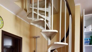 A compact kitchen with a white spiral staircase, a sink, and a washing machine. - Sea view apartment with 2 bedrooms and 2 bathrooms and 1 living room (Lido di Pomposa)