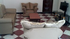 Una sala de estar con sofá, sillón y una pequeña mesa.