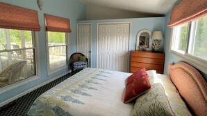A bedroom with a bed, dresser, and two doors. - Silver Thatch -4BR home Close to the beach. Linens and Towels Provided. (Chincoteague)