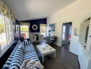 A living room with a sofa, chairs, a coffee table, and a television. - Silver Thatch -4BR home Close to the beach. Linens and Towels Provided. (Chincoteague)