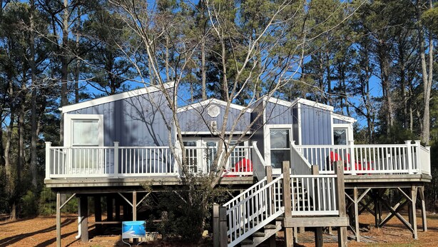 A cabin with two decks, wooden railings, and a small porch. - Silver Thatch -4BR home Close to the beach. Linens and Towels Provided. (Chincoteague)