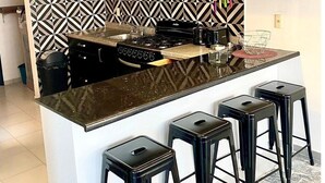 A modern kitchen with a black and white patterned backsplash, a central island with stools, and pendant lighting. - HUGE. FULL APARTMENT 100% REMODELED EXPO AREA (Zapopan)