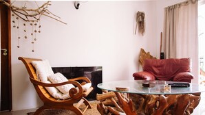 A living room with a wooden rocking chair, a glass coffee table, and a red sofa. - south hill villa (Mahe)