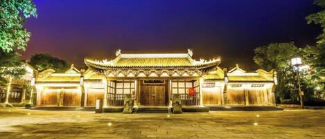 A traditional building with a tiled roof and a central entrance.