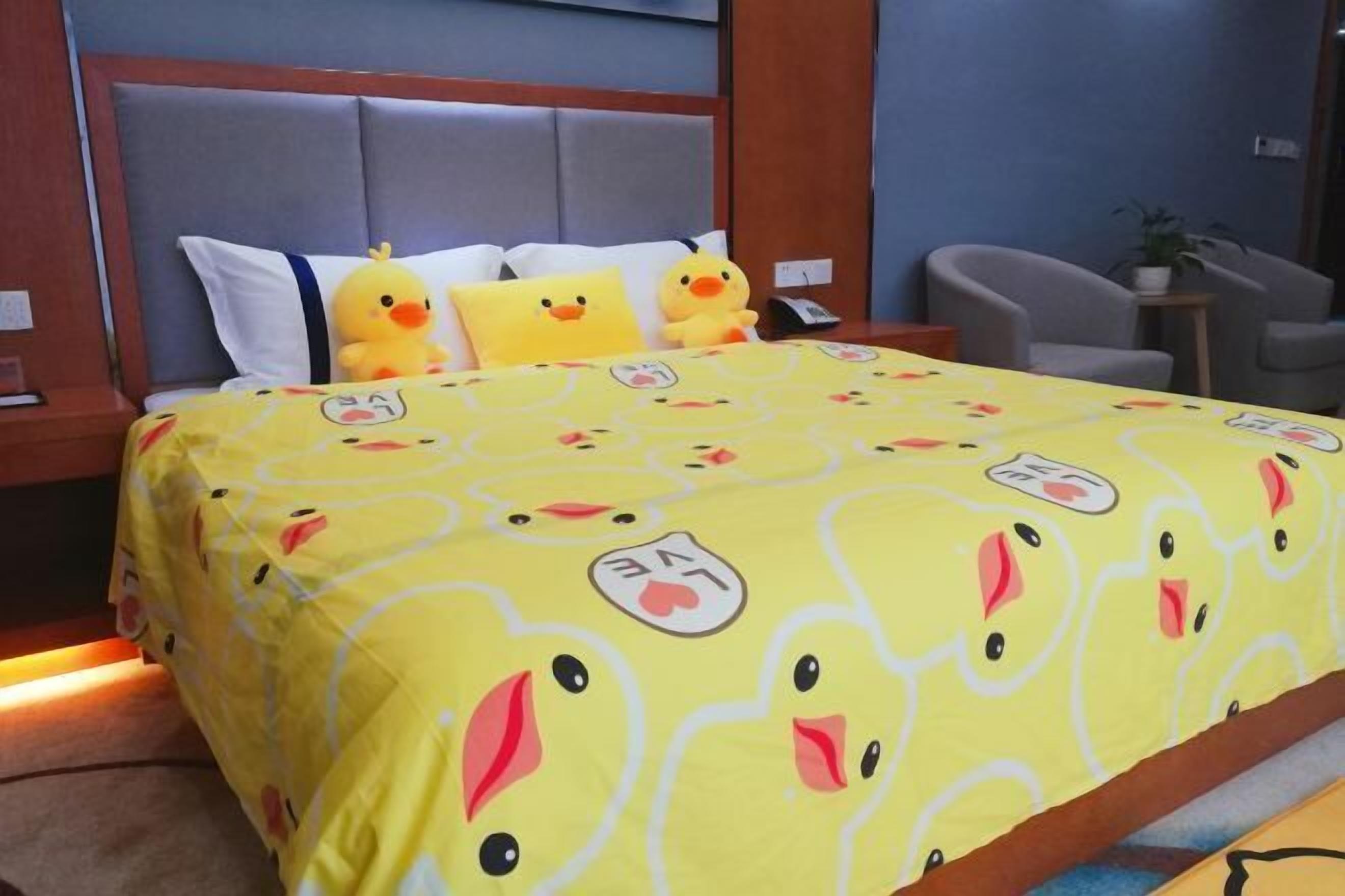 A bedroom with a bed, pillows, and a bedside table.
