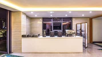 A modern kitchen with a central island, equipped with various appliances and a large window for natural light.