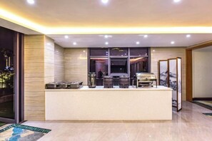 A modern kitchen with a central island, equipped with various appliances and a large window for natural light. - Chongqing Jinfeng Hotel (Chongqing)