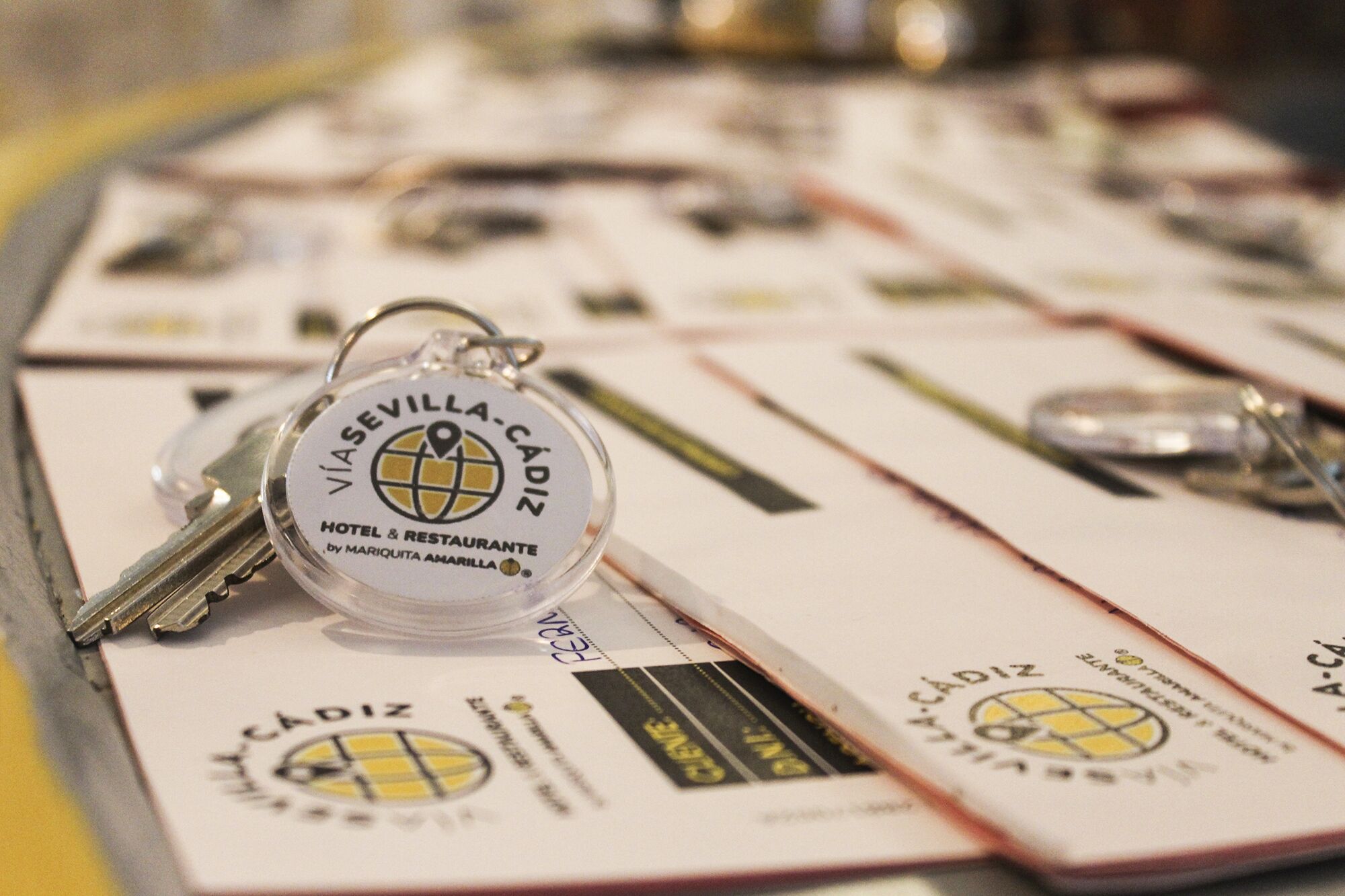 A keychain with a hotel name and logo, surrounded by business cards with similar branding.
