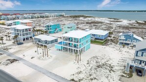 A coastal residential area with multiple two-story houses featuring balconies and a swimming pool.