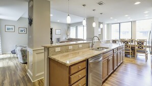 A modern kitchen with a large island, built-in appliances, and a dining area with wooden chairs. - Pet Friendly 4 bedroom/4 bathroom townhouse in Sea Pines, multi-family rental (Hilton Head)