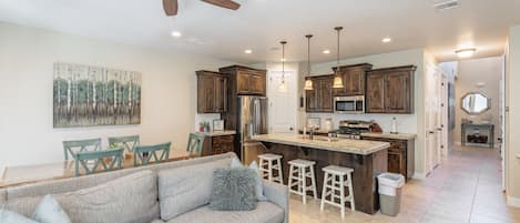 Una cocina moderna con una isla central, armarios de madera y taburetes de bar.