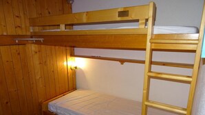 A bunk bed with a ladder, wooden walls, and a single light fixture. - 50m from resort center, 12nd floor, view firs, balcony, tv, 29m², Les Arcs (Les Arcs)