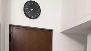 Eine geschlossene Holztür mit einer daran befestigten Wanduhr darüber.