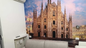 Ein Zimmer mit großem Fenster mit Blick auf ein Münster, einer Couch und einer Heizung.