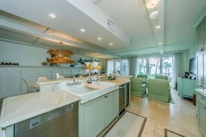 A spacious kitchen with a large island, built-in appliances, and a dining area with a sofa.