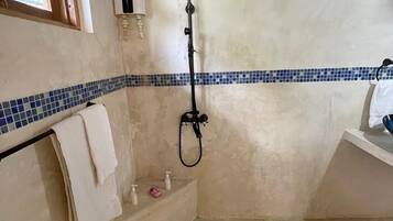 Un baño con ducha, toallero y ventana.