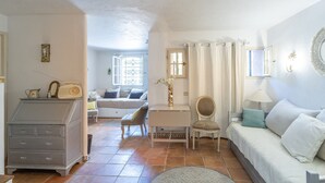 Una sala de estar acogedora con un sofá, un sillón, una mesita y un aparador.