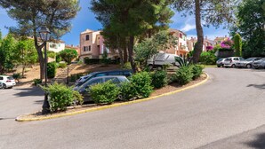 Una calle residencial con coches estacionados, una farola y casas con balcones.