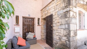 Edificio de paredes de piedra con una puerta de madera y un cartel con el número 83.