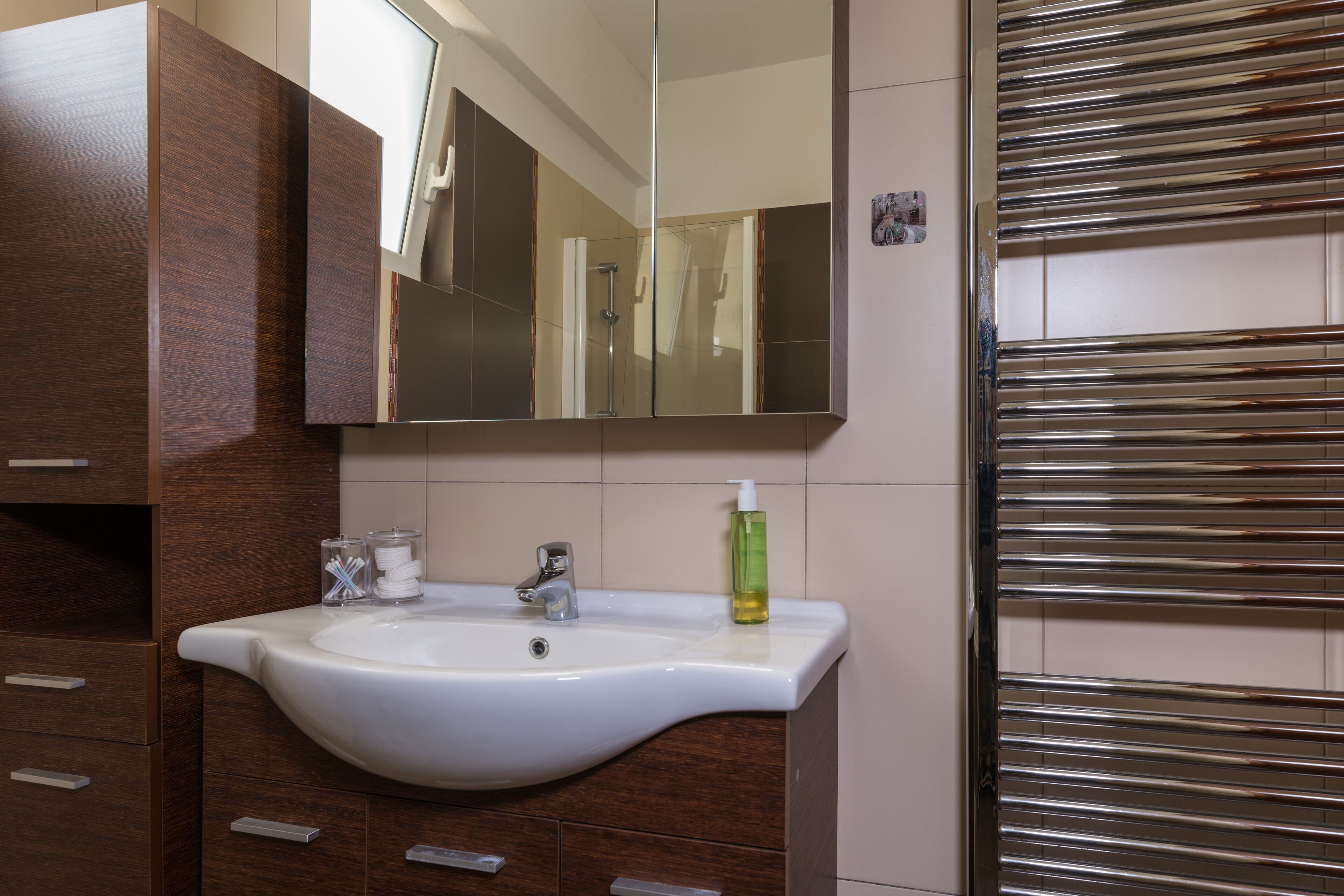 A bathroom with a white sink, a mirror, and a shower area.