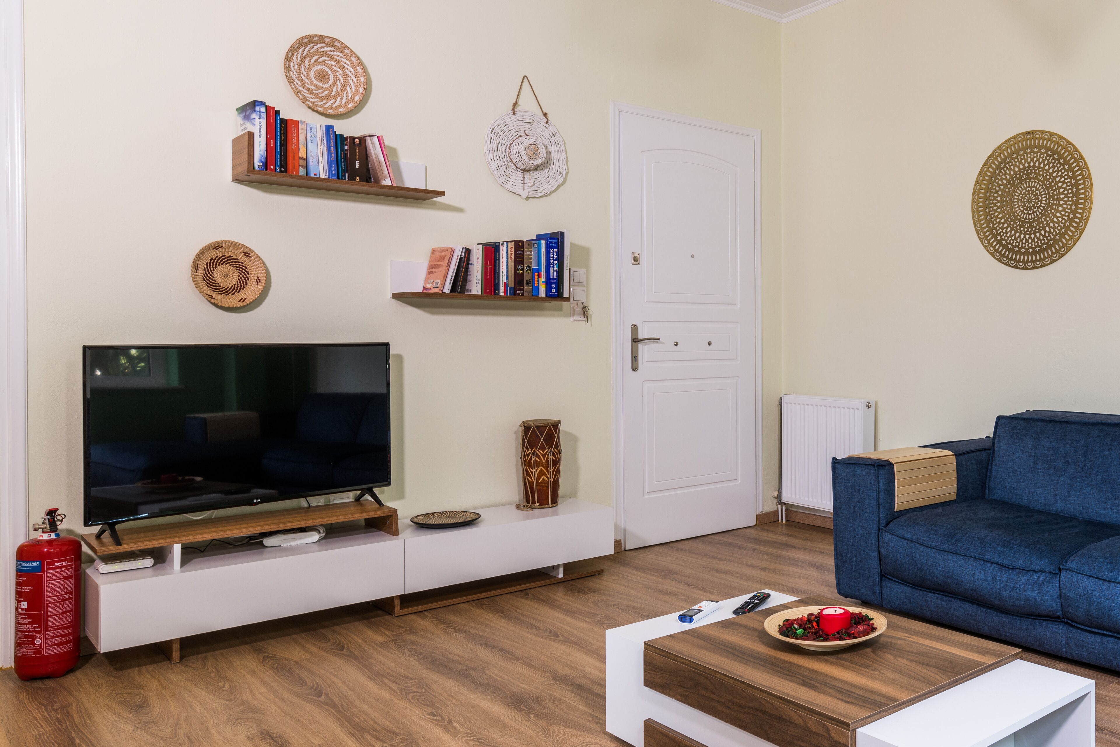 A living room with a TV, bookshelves, a blue sofa, and a coffee table.