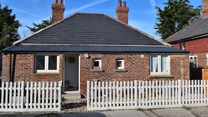 A brick house with a white picket fence, a chimney, and a small porch. - Seaside Retreat - Rye Harbour (Rye)